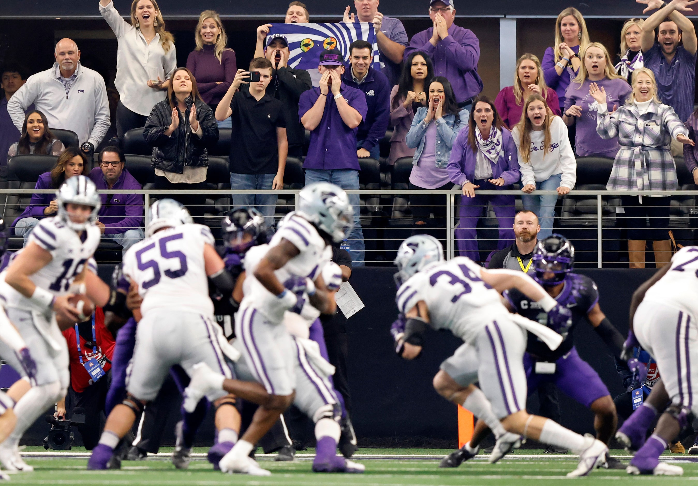 TCU Horned Frogs head coach Sonny Dykes’ wife Kate Golding (leaning on riling in purple...