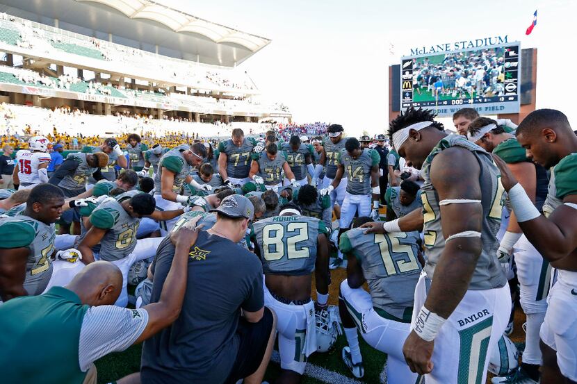 Baylor players and coaches pray after a 40-13 win over SMU at McLane Stadium in Waco, Texas,...