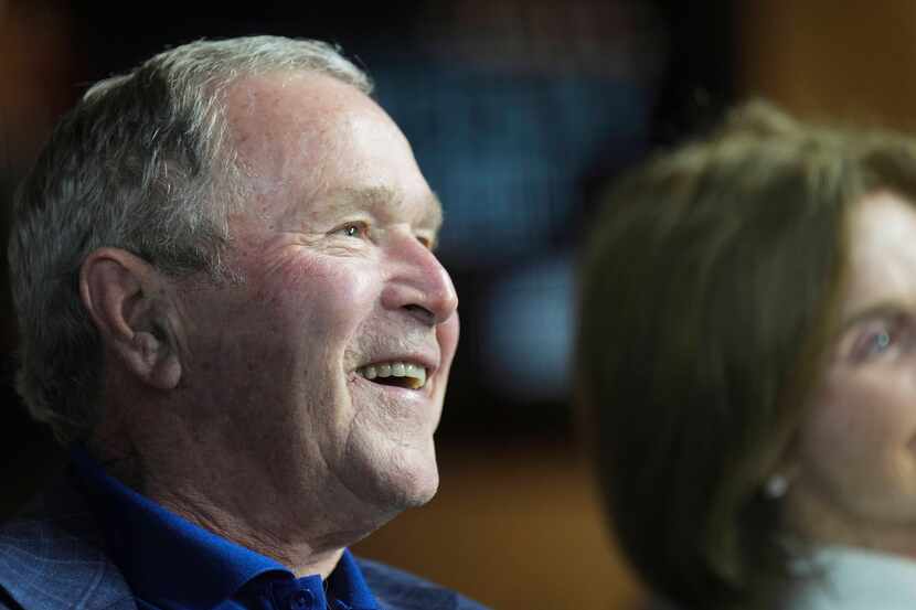 Former president George W. Bush and former first lady Laura Bush watch during the first...