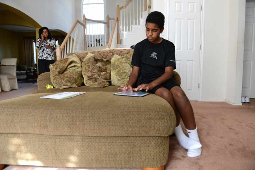 Roman Scott, 11, types on an iPad at his home in Cedar Hill. Scott was diagnosed with autism...