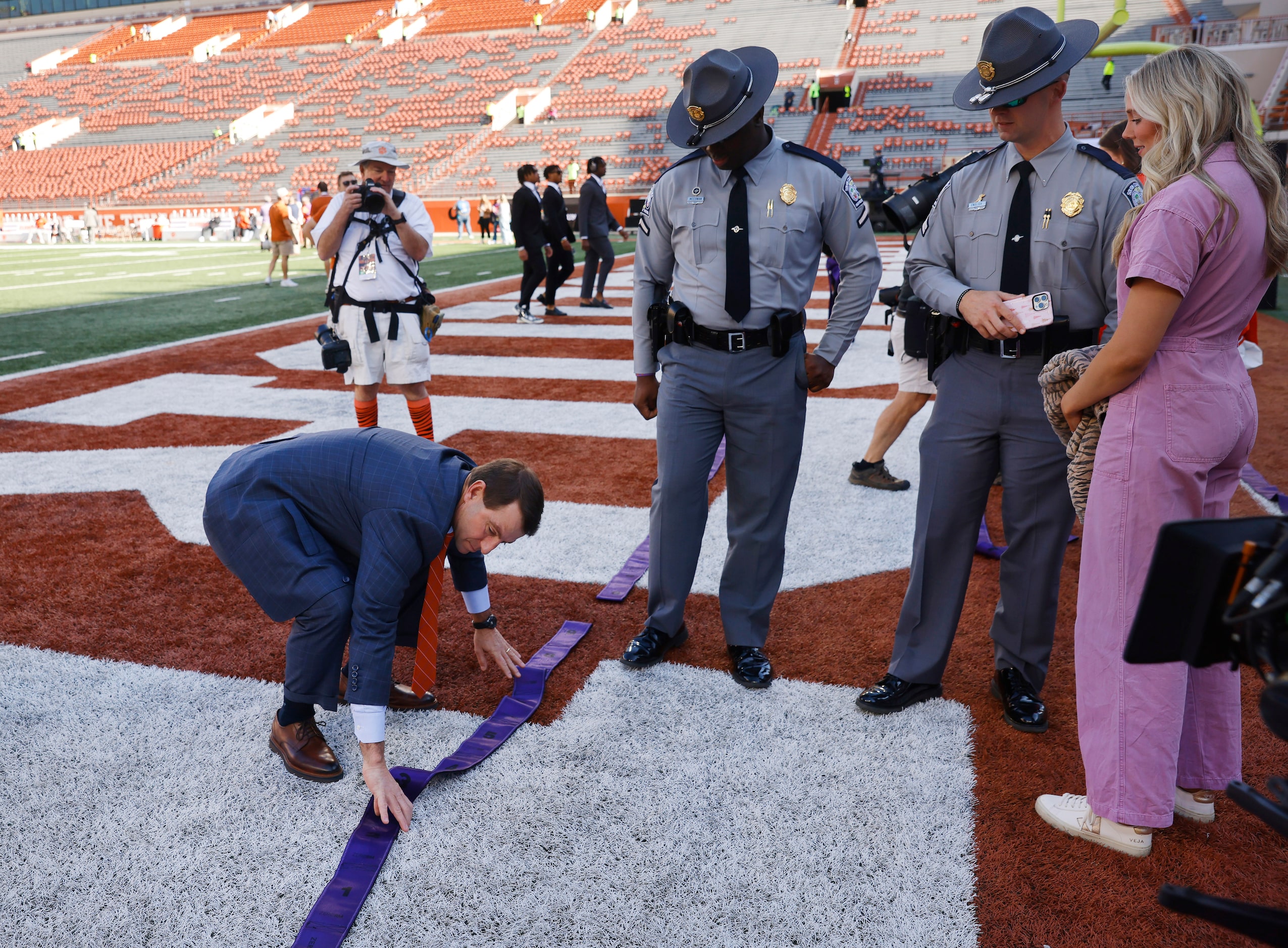 Clemson Tigers head coach Dabo Swinney straightens the workout equipment as he walks the...