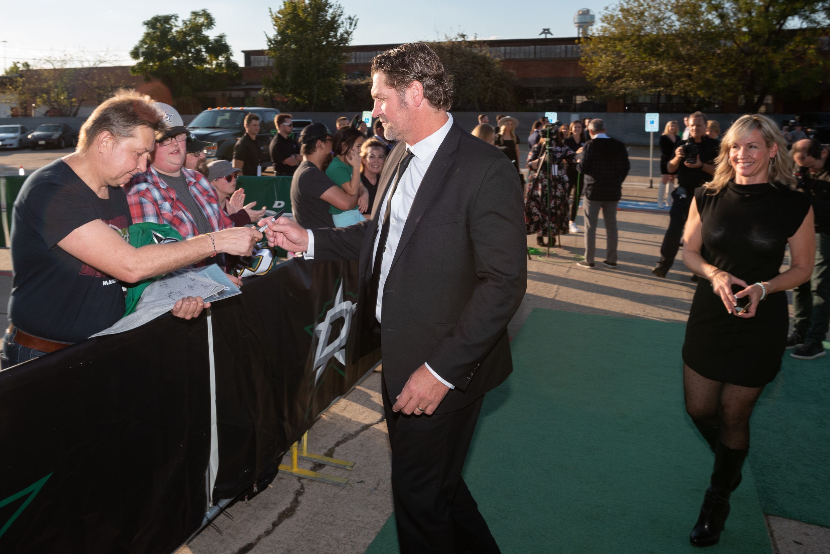 Former Dallas Stars player Derian Hatcher, center, greets fan Alexander Umnov, left, as...