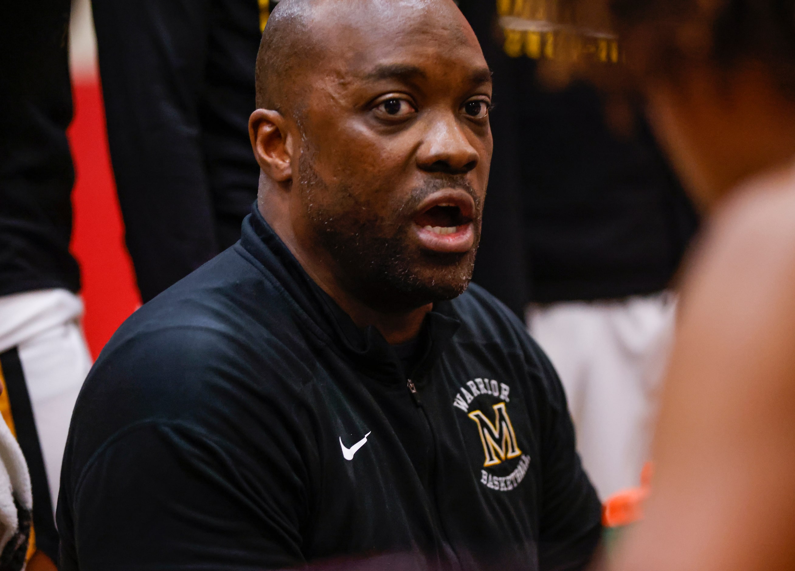 Memorial High School head coach Quinton Gibson talks to the team during a time out in the...