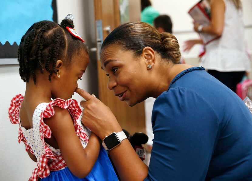 Tammia Rowe of Frisco with one of her twin daughters, Sofia Rowe (left), 5, on the first day...