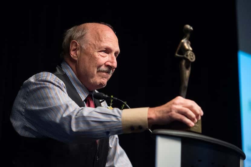 Dallas sports talk radio host Norm Hitzges displays an award he was given by the Press Club...