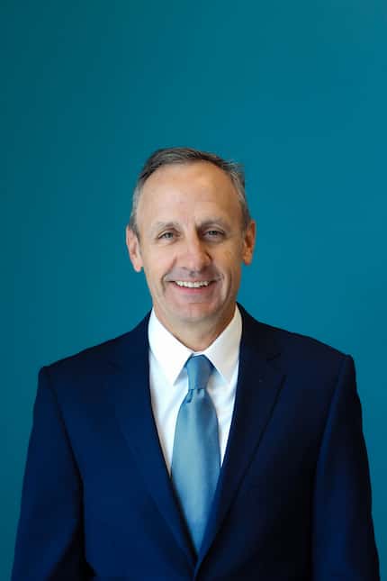 Image of Carl Burlbaw, wearing a suit with a blue background,