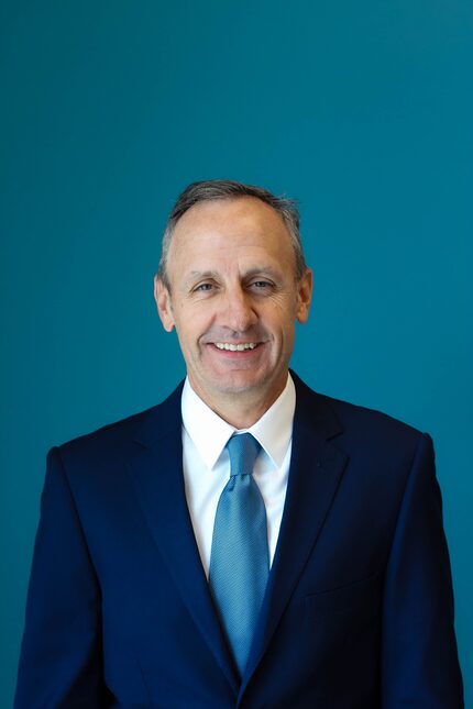 Image of Carl Burlbaw, wearing a suit with a blue background,