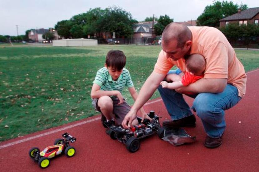 
Diego and José inspect a radio-controlled vehicle that was slightly damaged during...