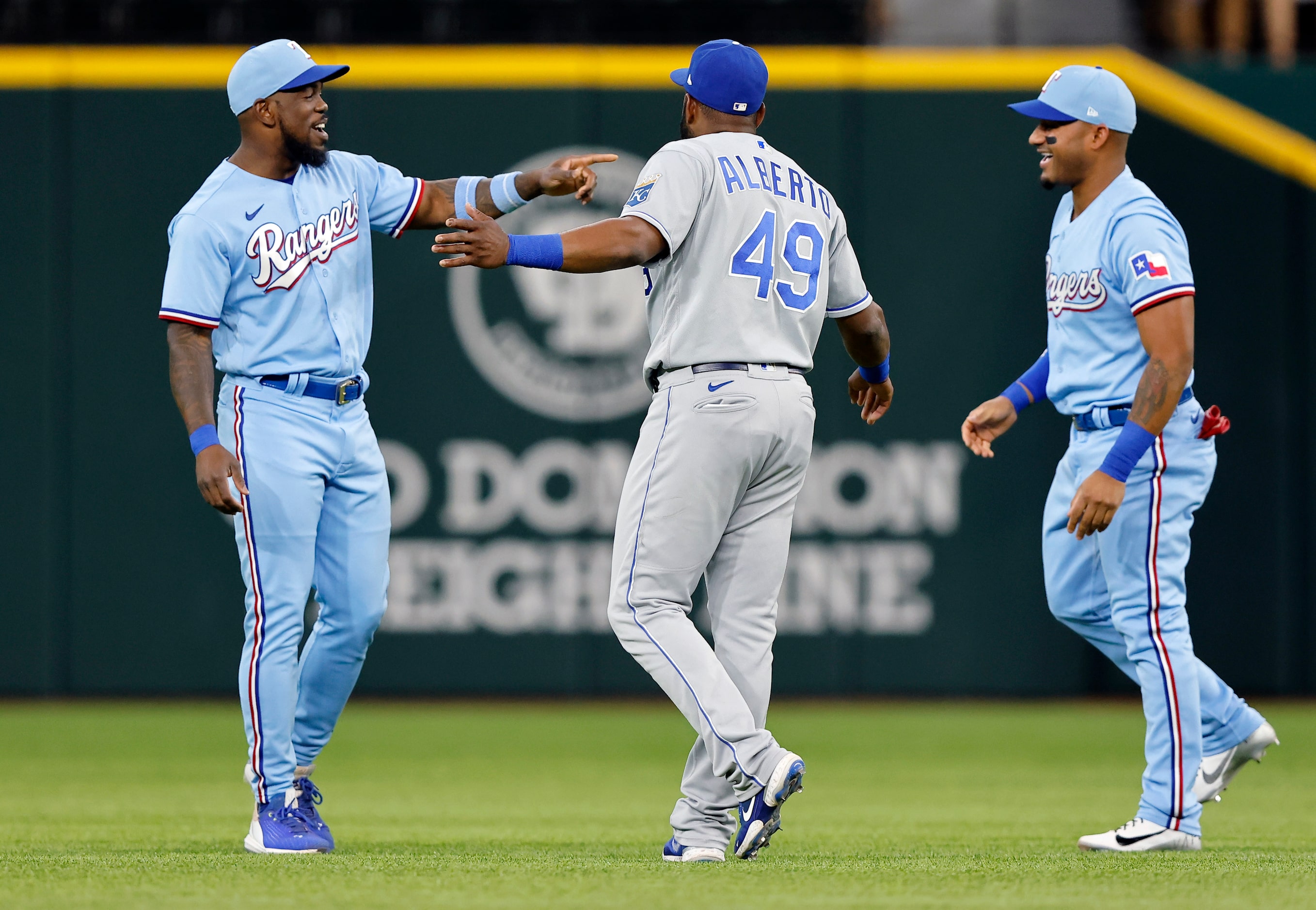 Texas Rangers Adolis Garcia (left) and Andy Ibanez (right) visit with Kansas City Royals...