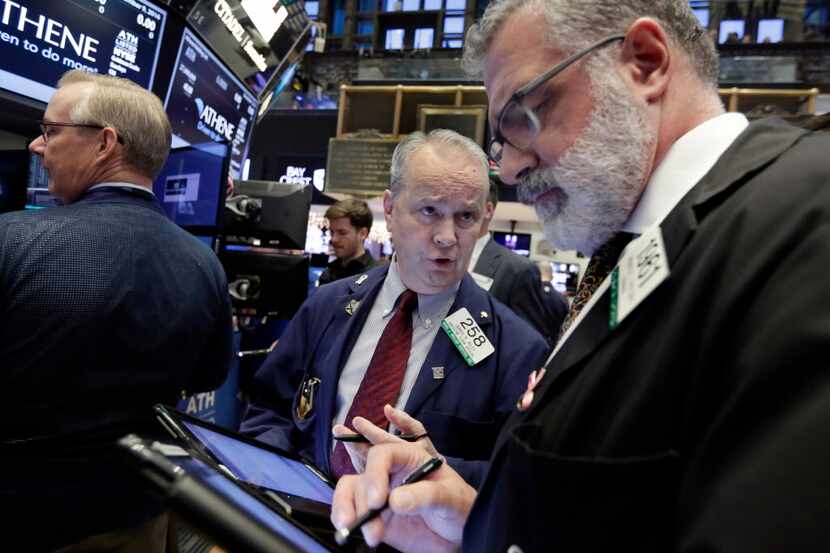 James Riley, center, talks with fellow trader Kenneth Polcari on the floor of the New York...