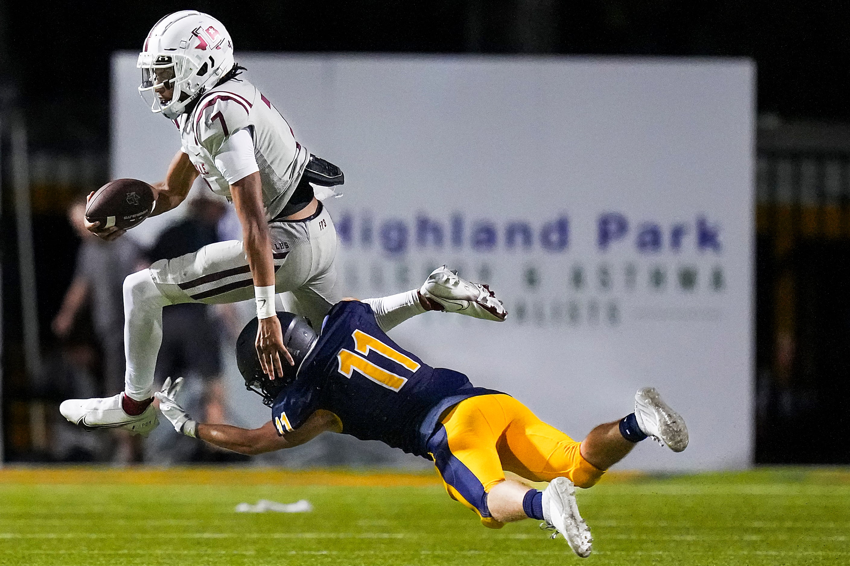 Lewisville quarterback Ethan Terrell (7) leaps past Highland Park’s Wesley Winfield (11)...