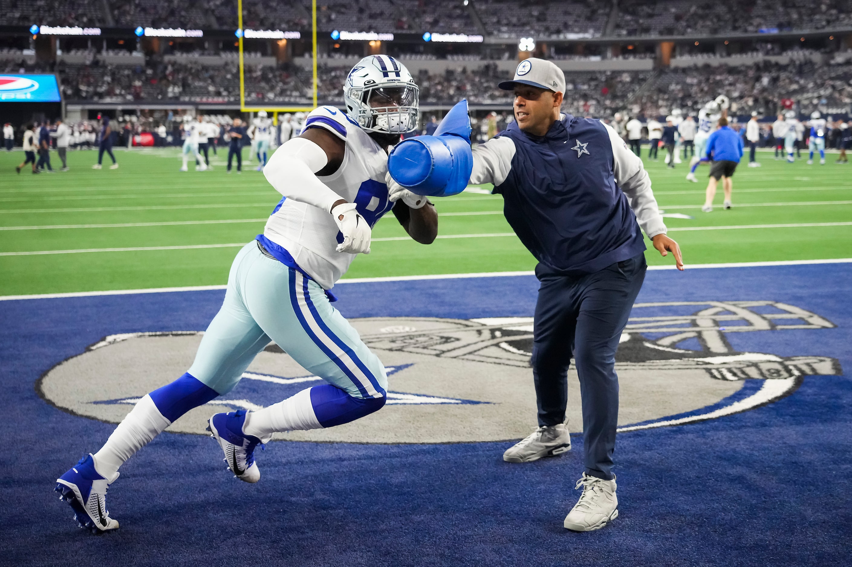 Dallas Cowboys defensive line coach Aden Durde works with defensive end DeMarcus Lawrence...