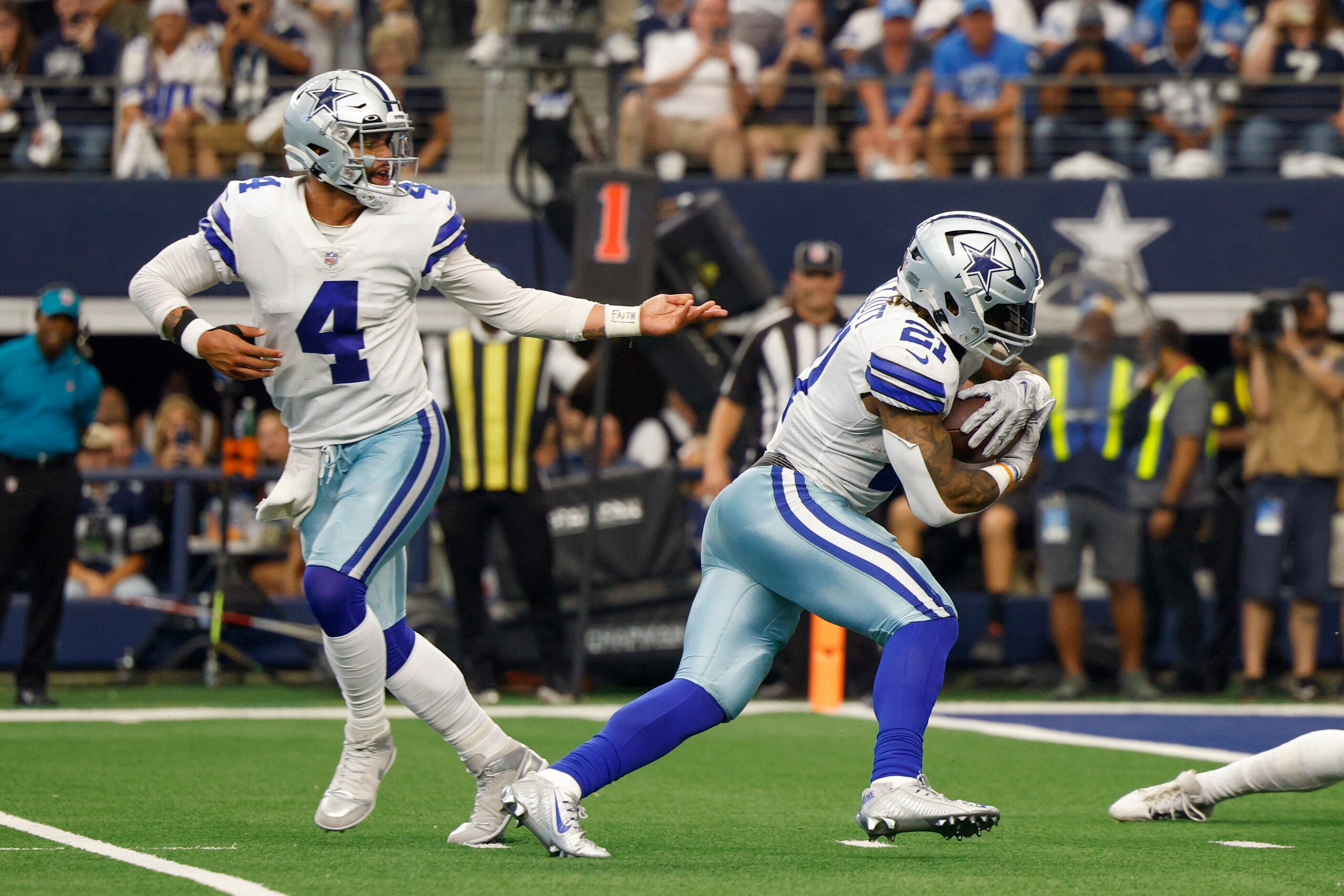 Dallas Cowboys quarterback Dak Prescott (4) hands the ball to running back Ezekiel Elliott...