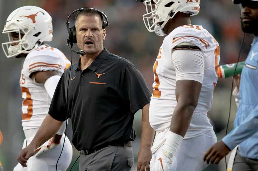 Texas defensive coordinator Todd Orlando, second from left, talks with his players during an...