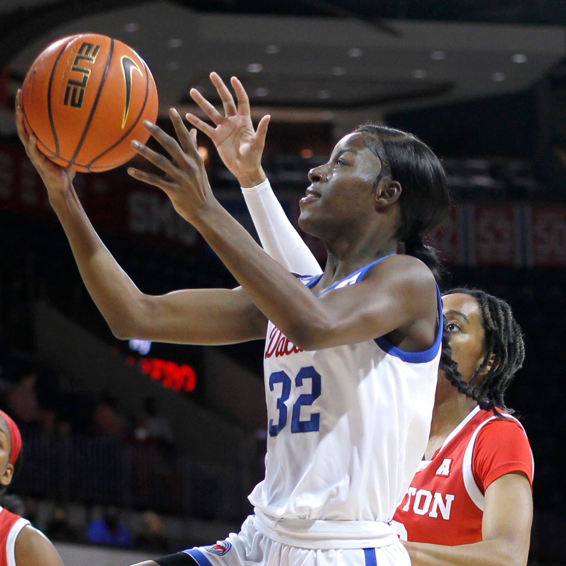 SMU guard Kayla White (32) drives to the basket past the defense of Houston guard Britney...