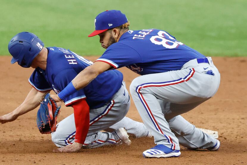 Texas Rangers outfielder Scott Heineman gets back to second safely on a thrown down to...