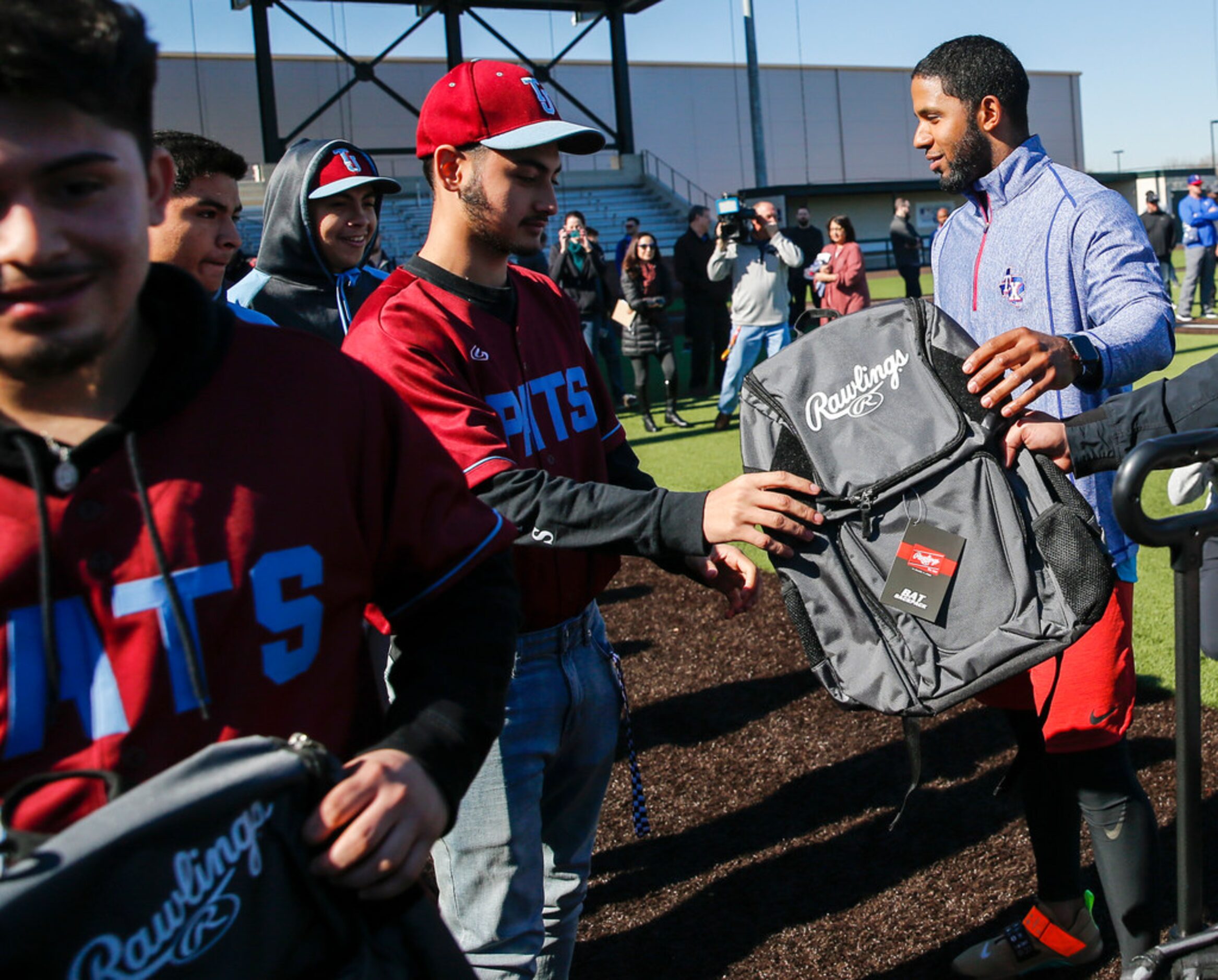 Rangers shortstop Elvis Andrus, right, donates baseball and softball equipment to Thomas...