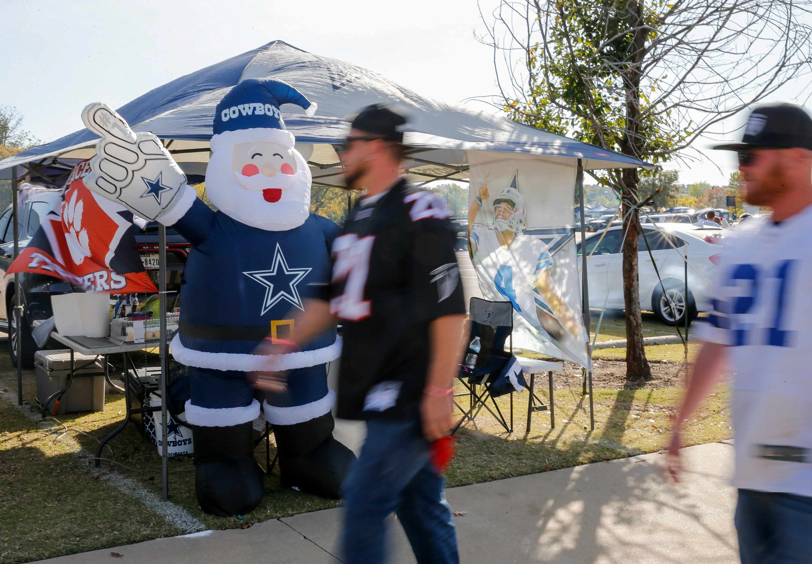 Fans walk past a Dallas Cowboys Santa before an NFL football game between the Dallas Cowboys...