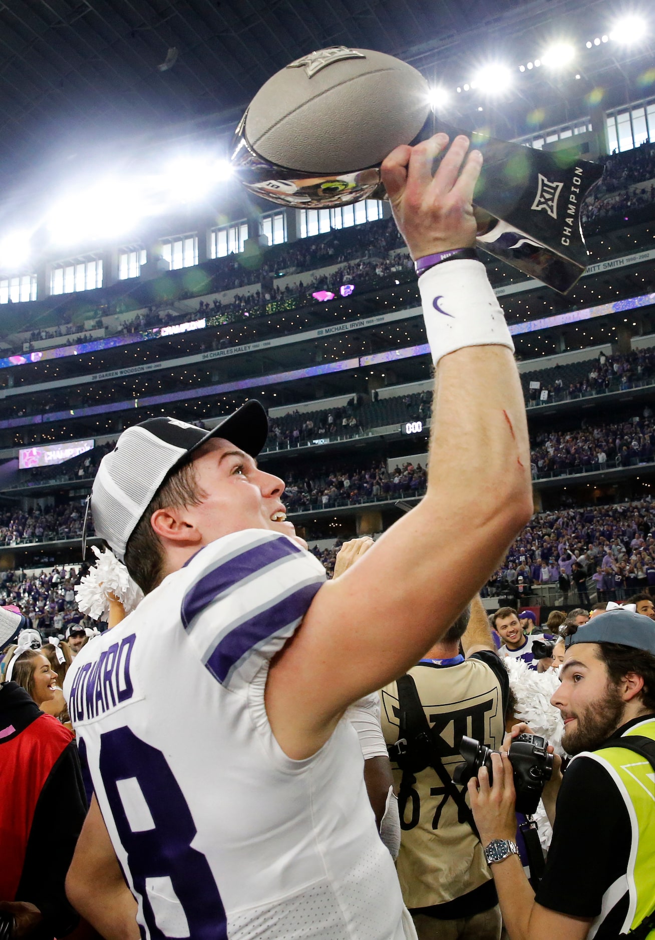 Kansas State Wildcats quarterback Will Howard (18) raises the Big XII Championship trophy...