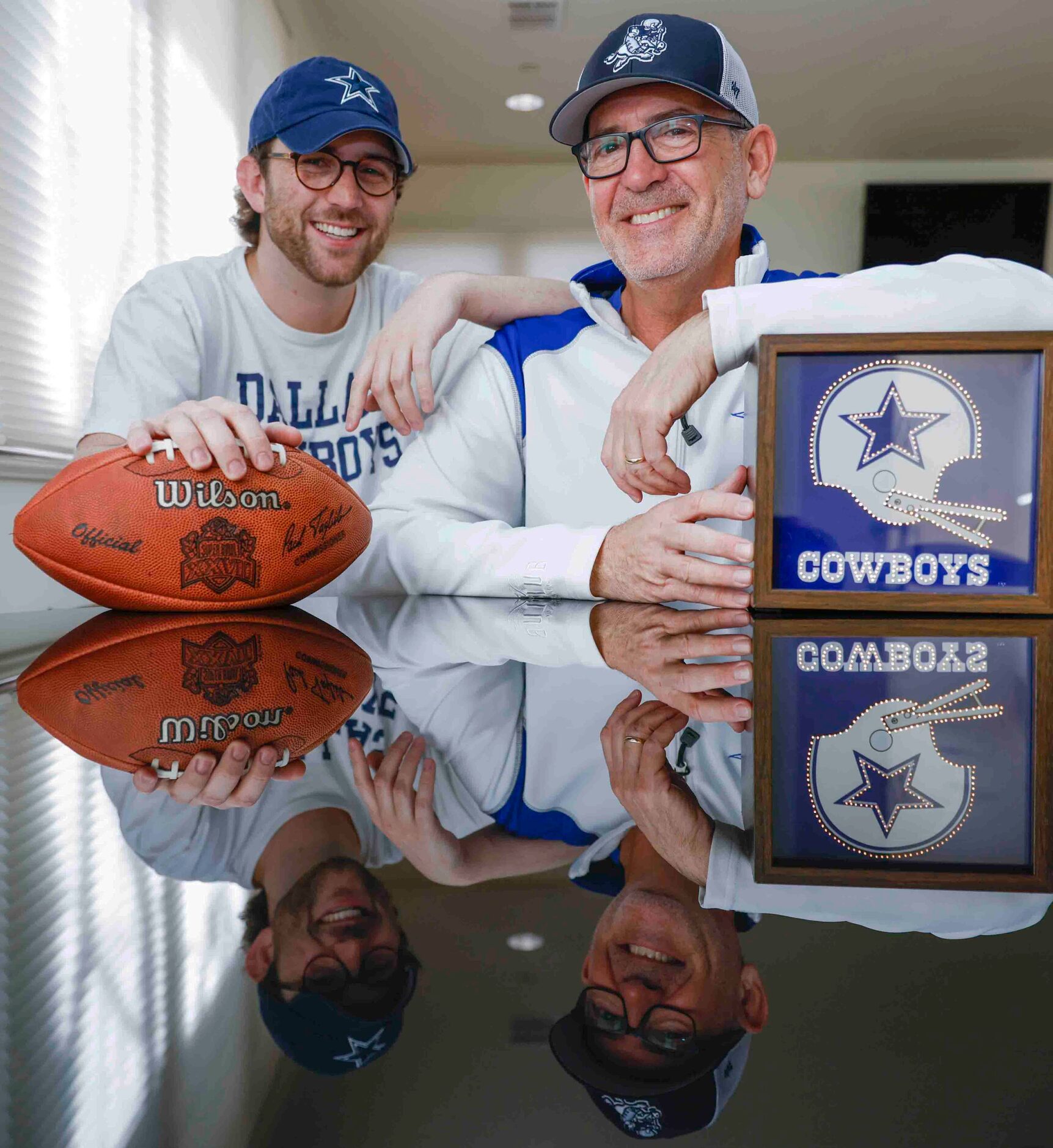 Cowboys fans Miles, right, and his father Marc Andres poses for portrait session with the...