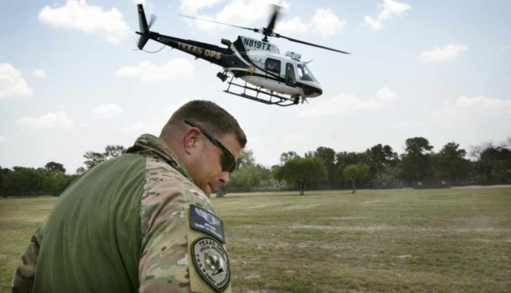 Un agente del Departamento de Seguridad Pública de Texas ve el despegue de un helicóptero...