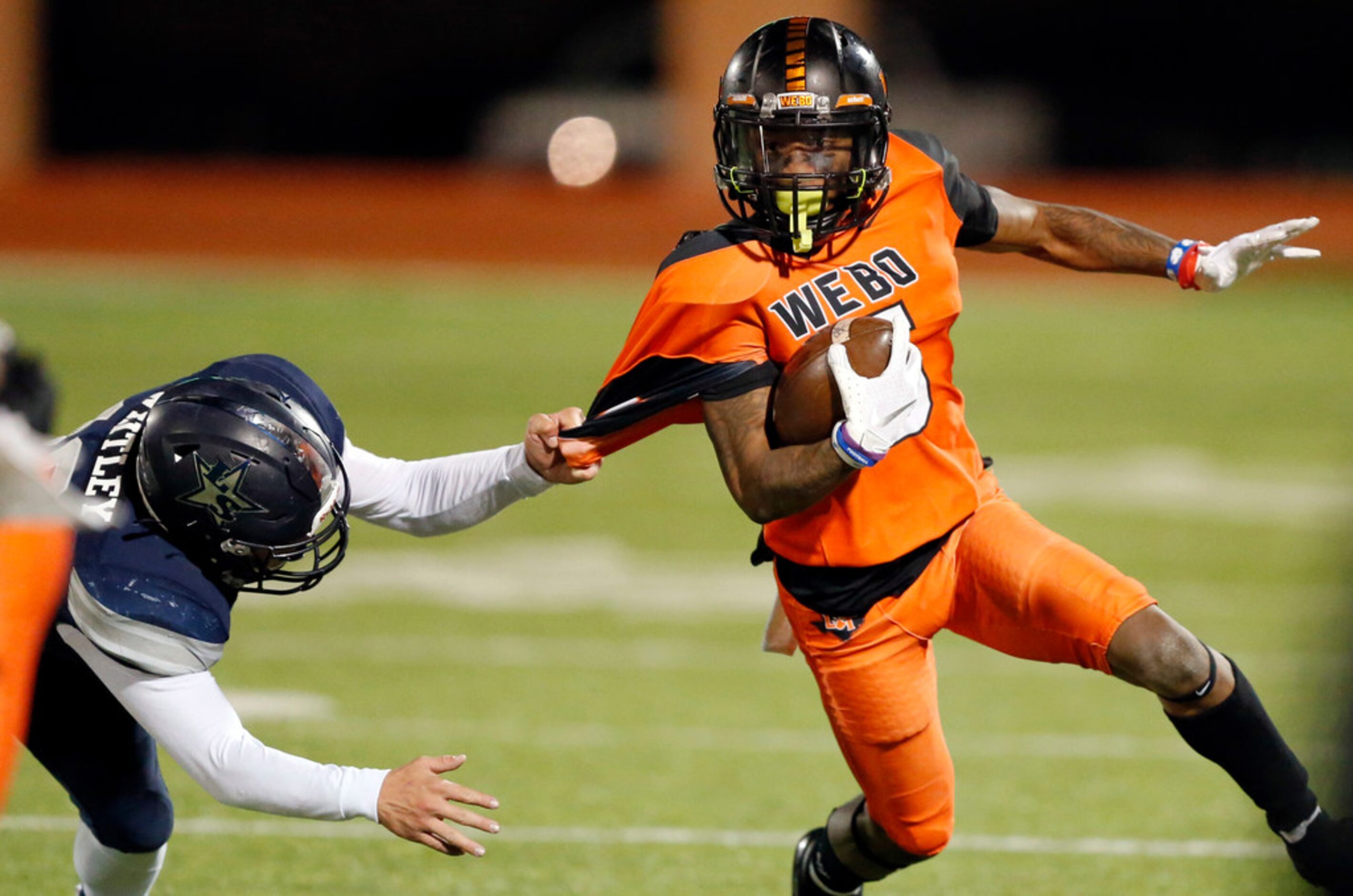 Frisco Lone Star defensive back Landon Whitley (19) barely hangs onto Lancaster Majik Rector...