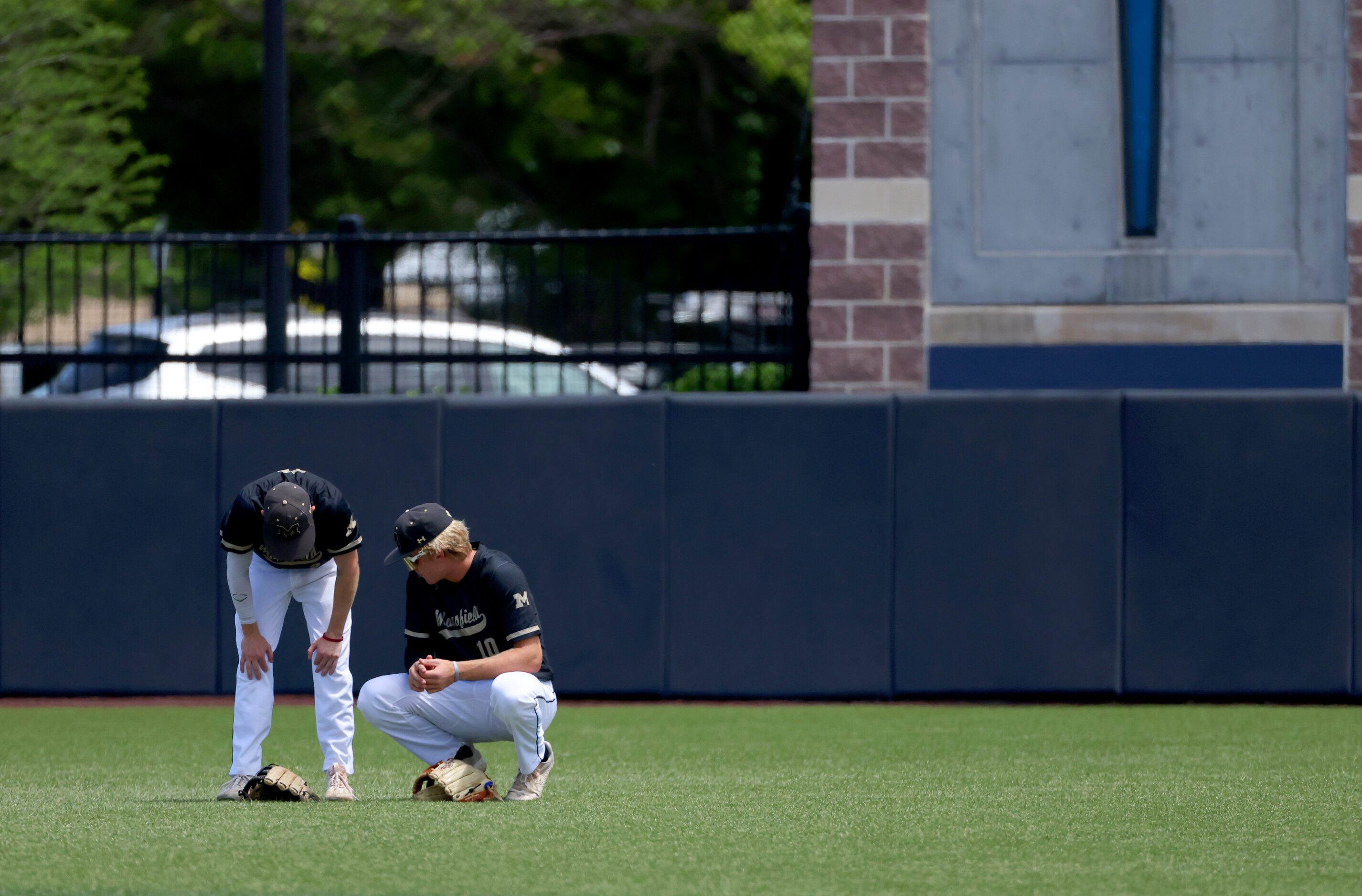 Mansfield outfielders rest between innings of an area round game of the UIL baseball...