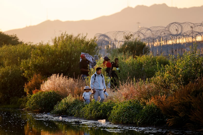 Migrants wait behind concertina wire on the U.S. side of the Rio Grande at Gate 42 in El...