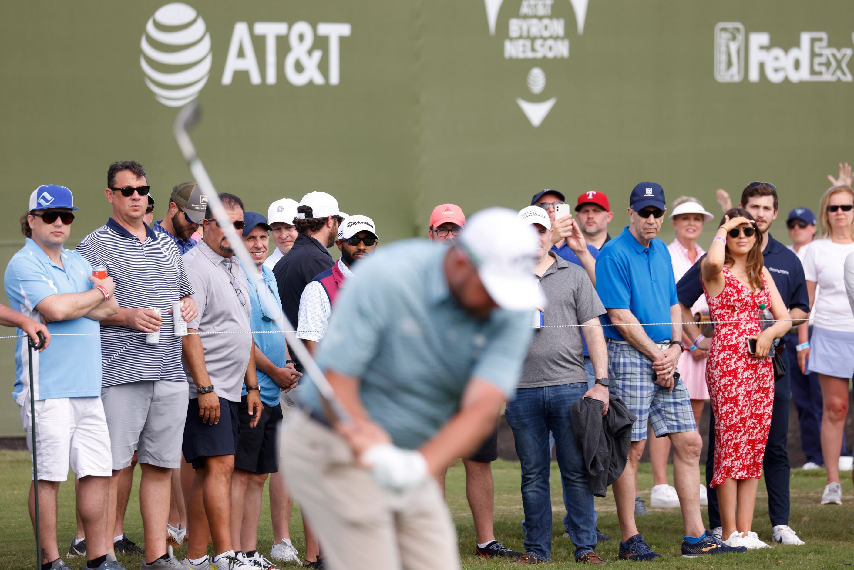 Fans watch as Marc Leishman tees off on the 17th hole during round 2 of the AT&T Byron...