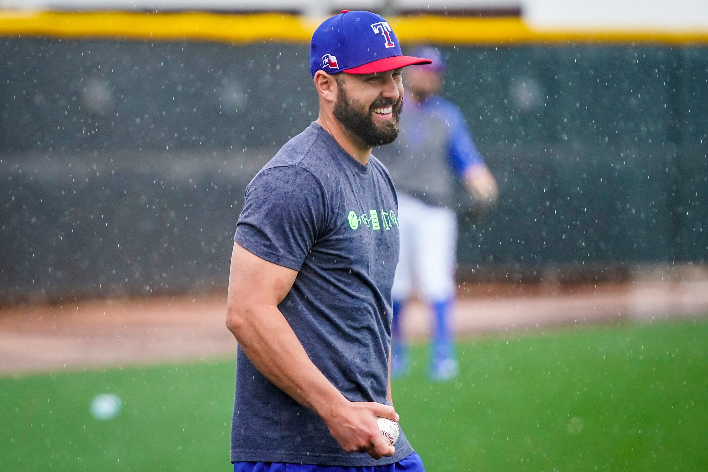 Texas Rangers pitcher Nick Goody laughs while playing long toss with Tim Dillard as rain...