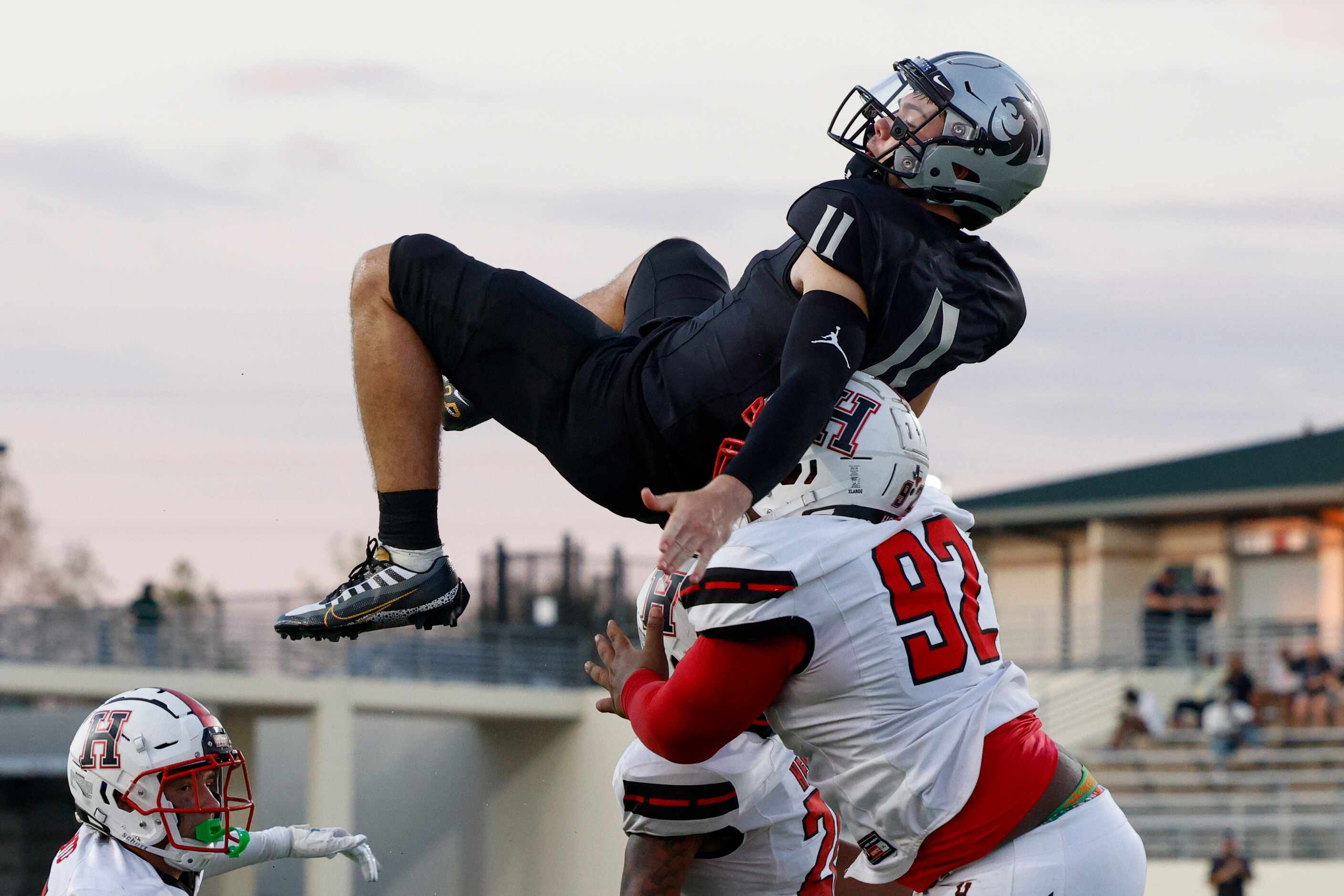 Denton Guyer quarterback Jackson Arnold (11) attempts to jump Rockwall-Heath defensive...