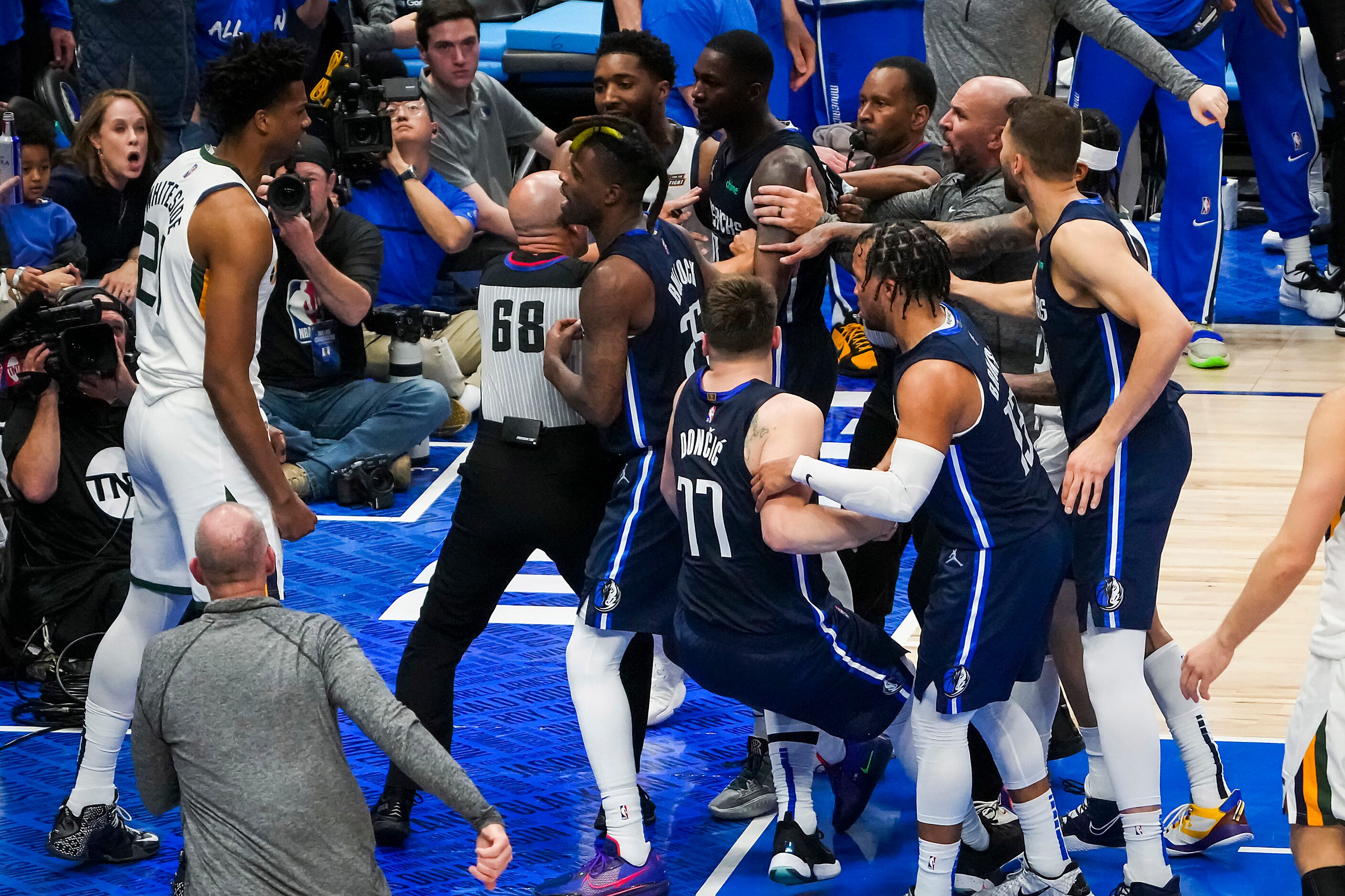 Players coaches and referees try to separate Dallas Mavericks forward Dorian Finney-Smith...