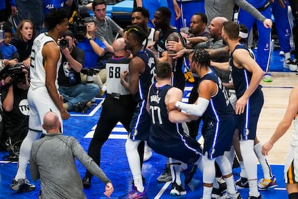 Players coaches and referees try to separate Dallas Mavericks forward Dorian Finney-Smith...