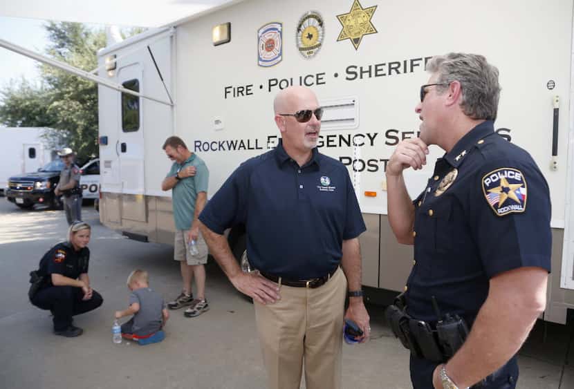 Rockwall City Council member Kevin Fowler (center) talks to Rockwall Police Chief Kirk Riggs...