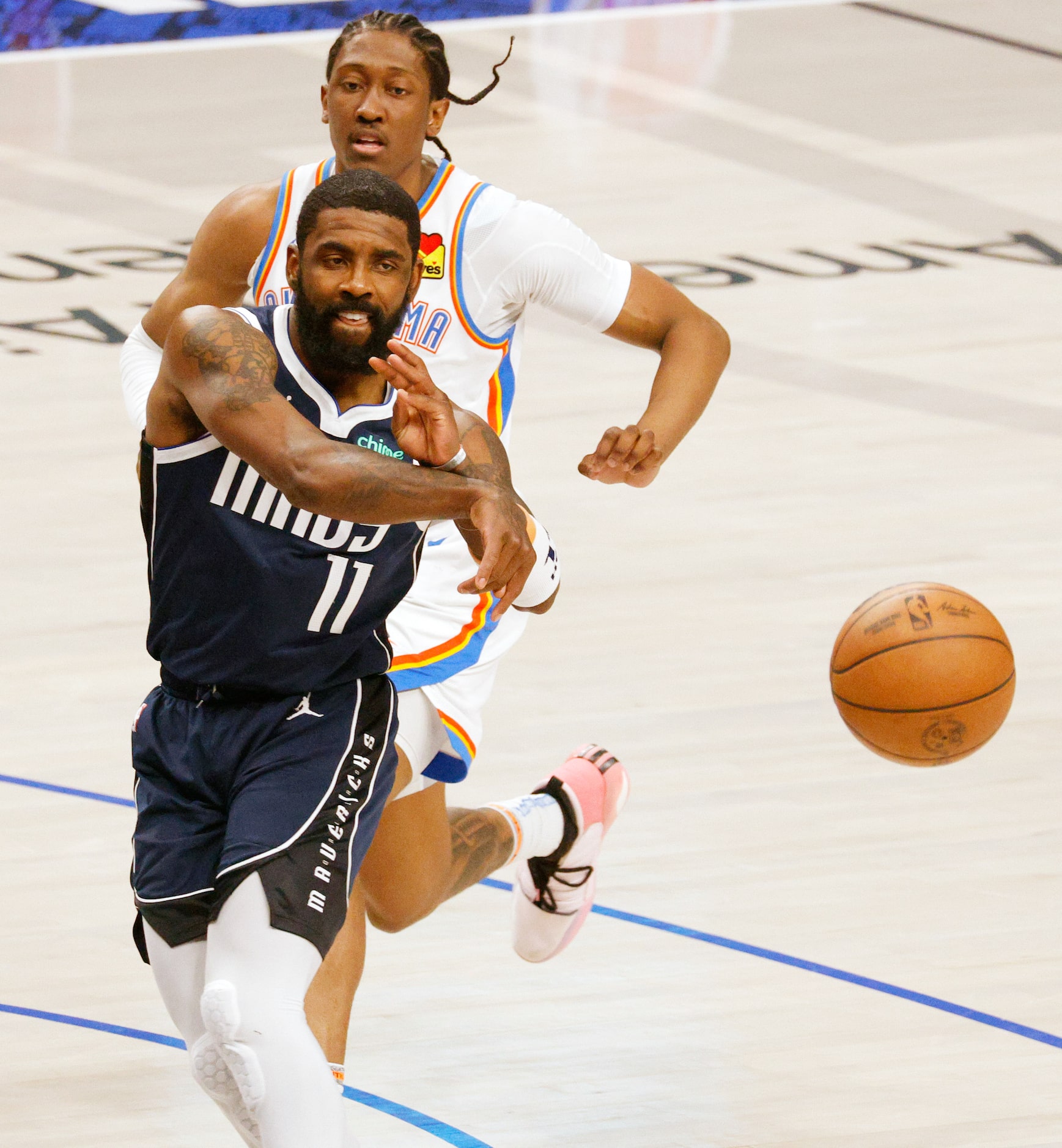 Dallas Mavericks guard Kyrie Irving (11) throws a ball as Oklahoma City Thunder forward...