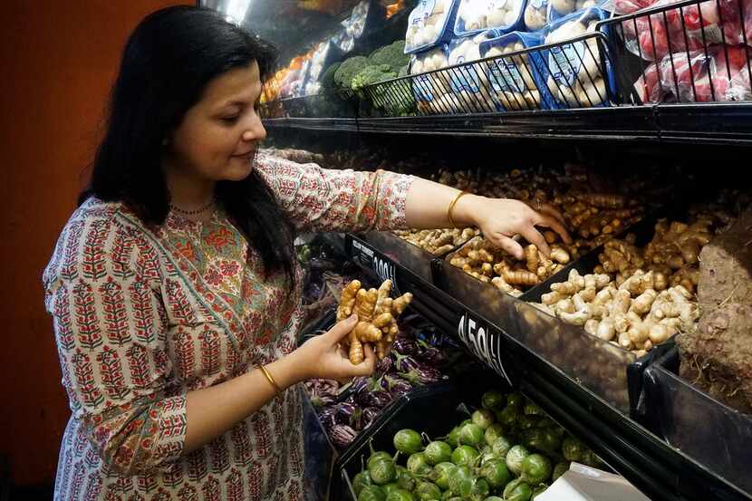 In this file photo, Sapna Punjabi-Gupta grabs some turmeric root while shopping at the India...