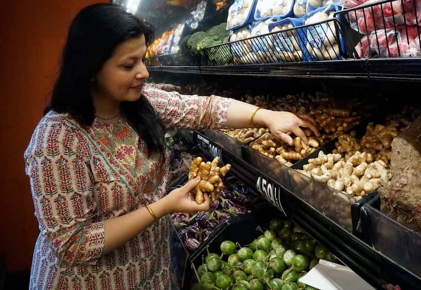 Sapna Punjabi-Gupta grabs some turmeric root while shopping at the India Bazaar in Irving.