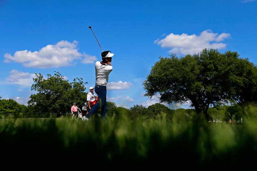 Kevin Na watches his second shot from the rough on the 9th fairway during the first round of...