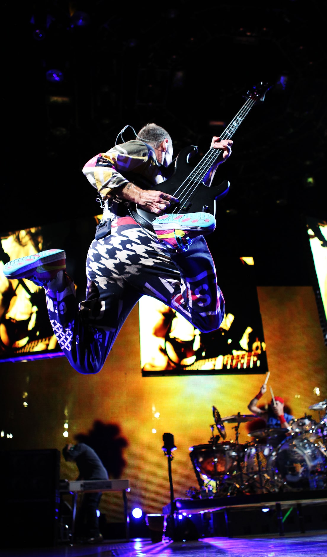 Red Hot Chili Peppers bassist Flea leaps into the air during the Chili Peppers' show Oct. 2...