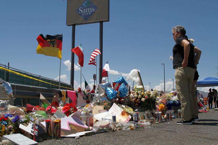 FILE - Mourners visit a makeshift memorial on Aug. 12, 2019, near the Walmart in El Paso,...