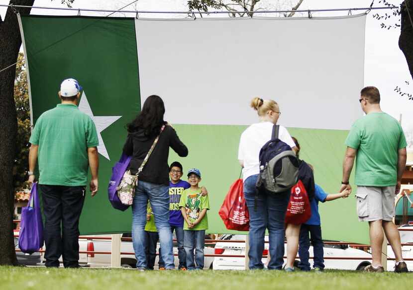Visitors pose for photos in front of a St. Patrick's day themed Texas flag during the Fort...