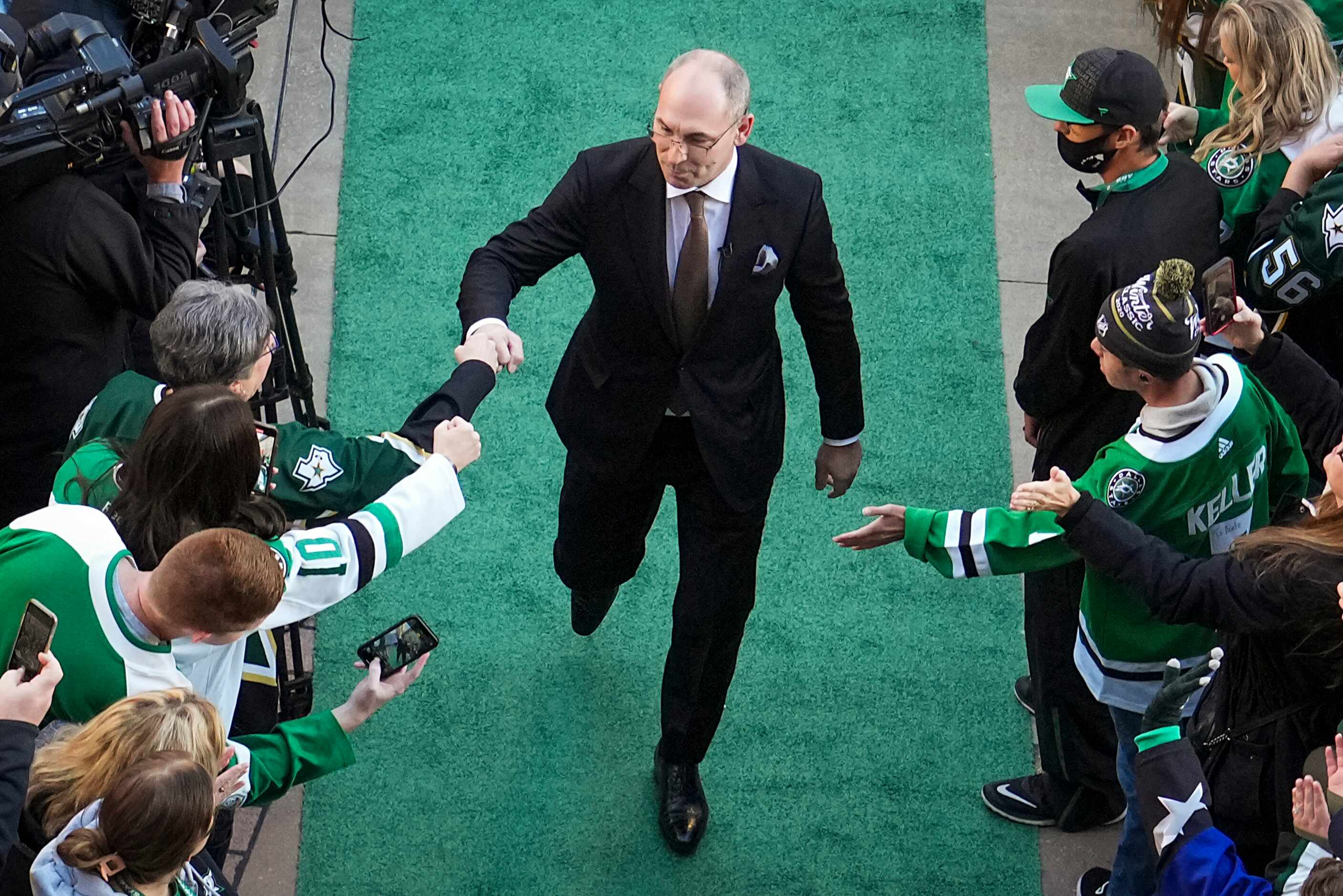 Former Dallas Stars player Sergei Zubov fist bumps fans as he arrives for his jersey...