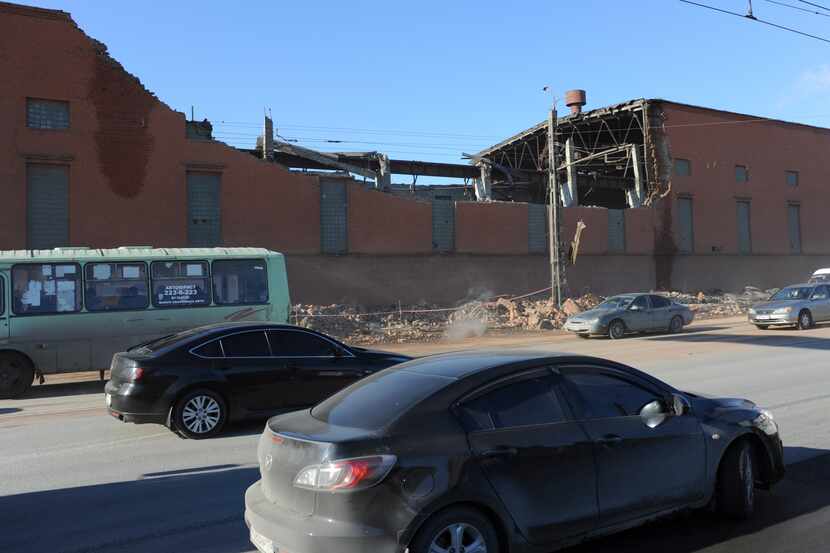 Cars pass by a zinc factory building with it's roof collapsed in Chelyabinsk, about 1500...
