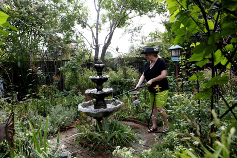 Christy Hodges fills the fountain in her traditional English garden on September 13, 2013 at...