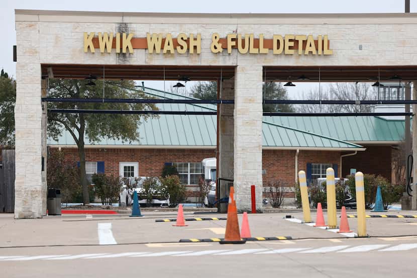 An employee of a Kwik Kar Lube & Car Wash, seen near Safari Kid day care in the background,...
