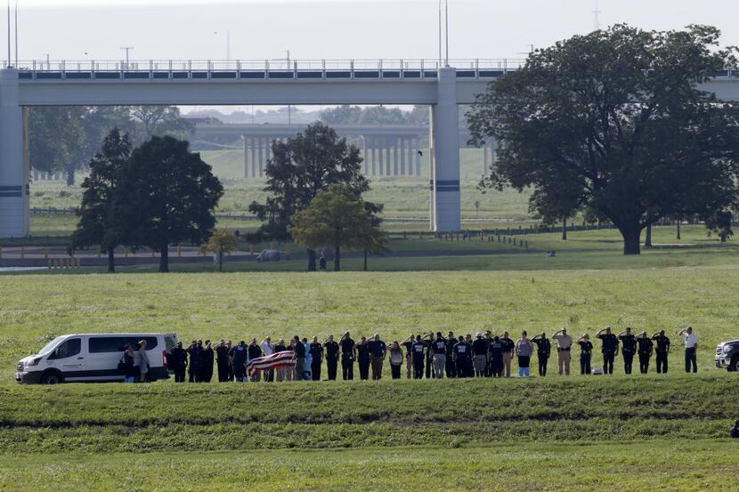 Officers saluted as a body presumed to be that of missing SMU police Officer Mark McCullers...