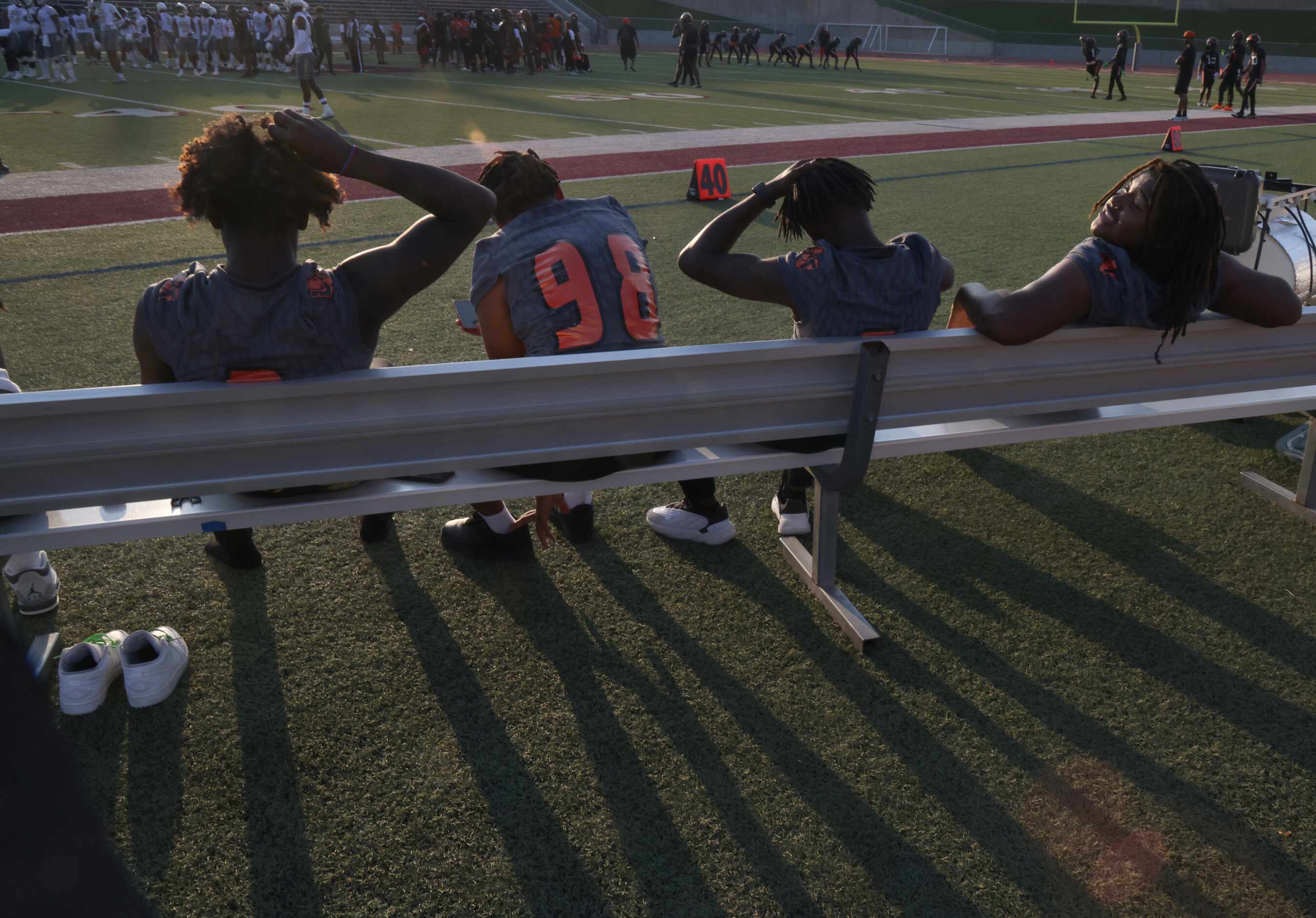Lancaster non- starters rest on the team bench during warm-ups before the opening kickoff of...