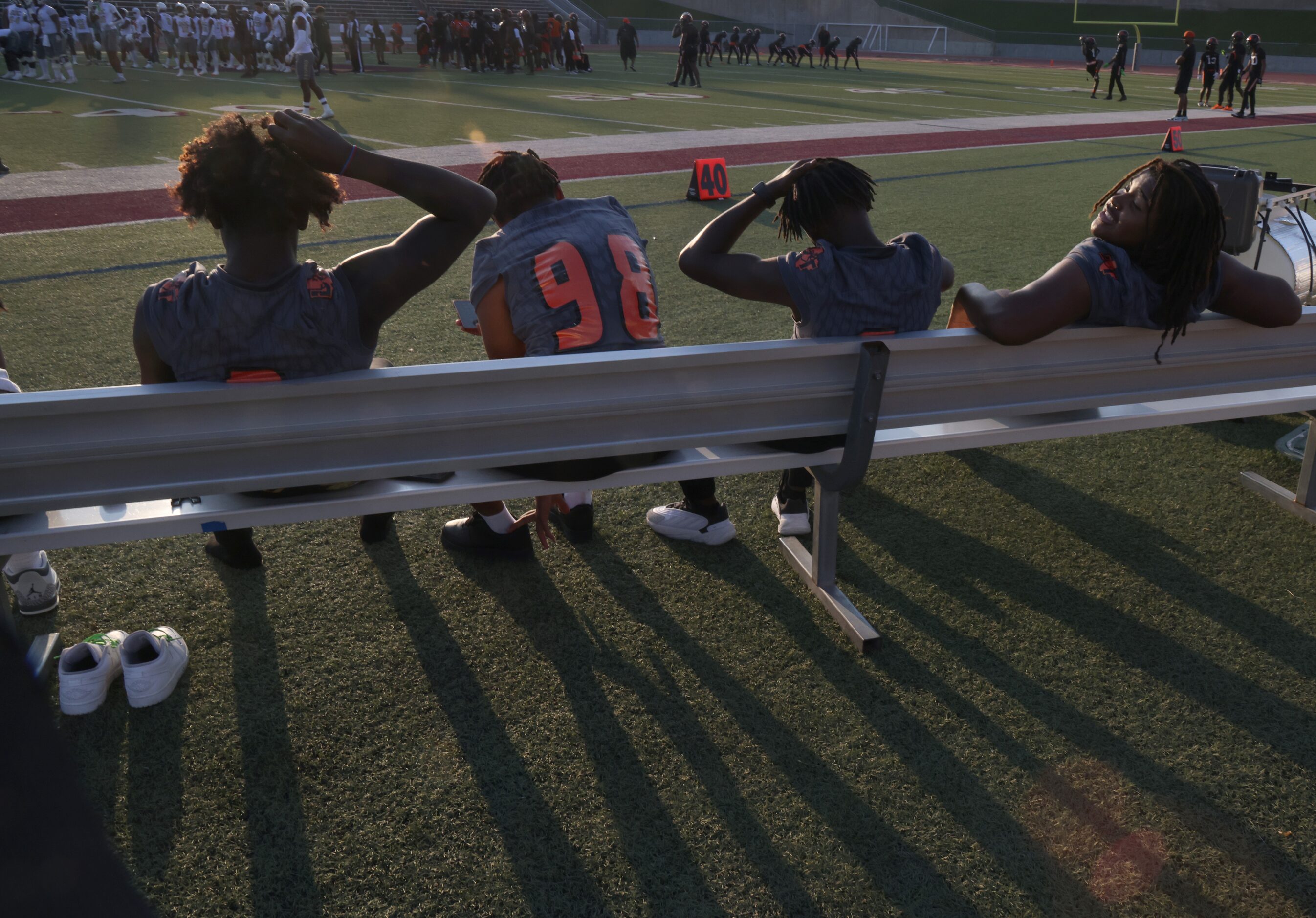 Lancaster non- starters rest on the team bench during warm-ups before the opening kickoff of...