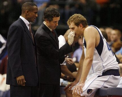 Dallas Mavericks assistant coach Dwane Casey (left) watches as forward Dirk Nowitzki is...