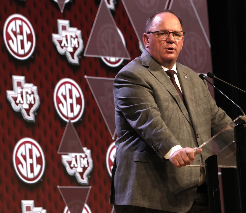 Texas A&M head football coach Mike Elko answers a question from a media member during the...